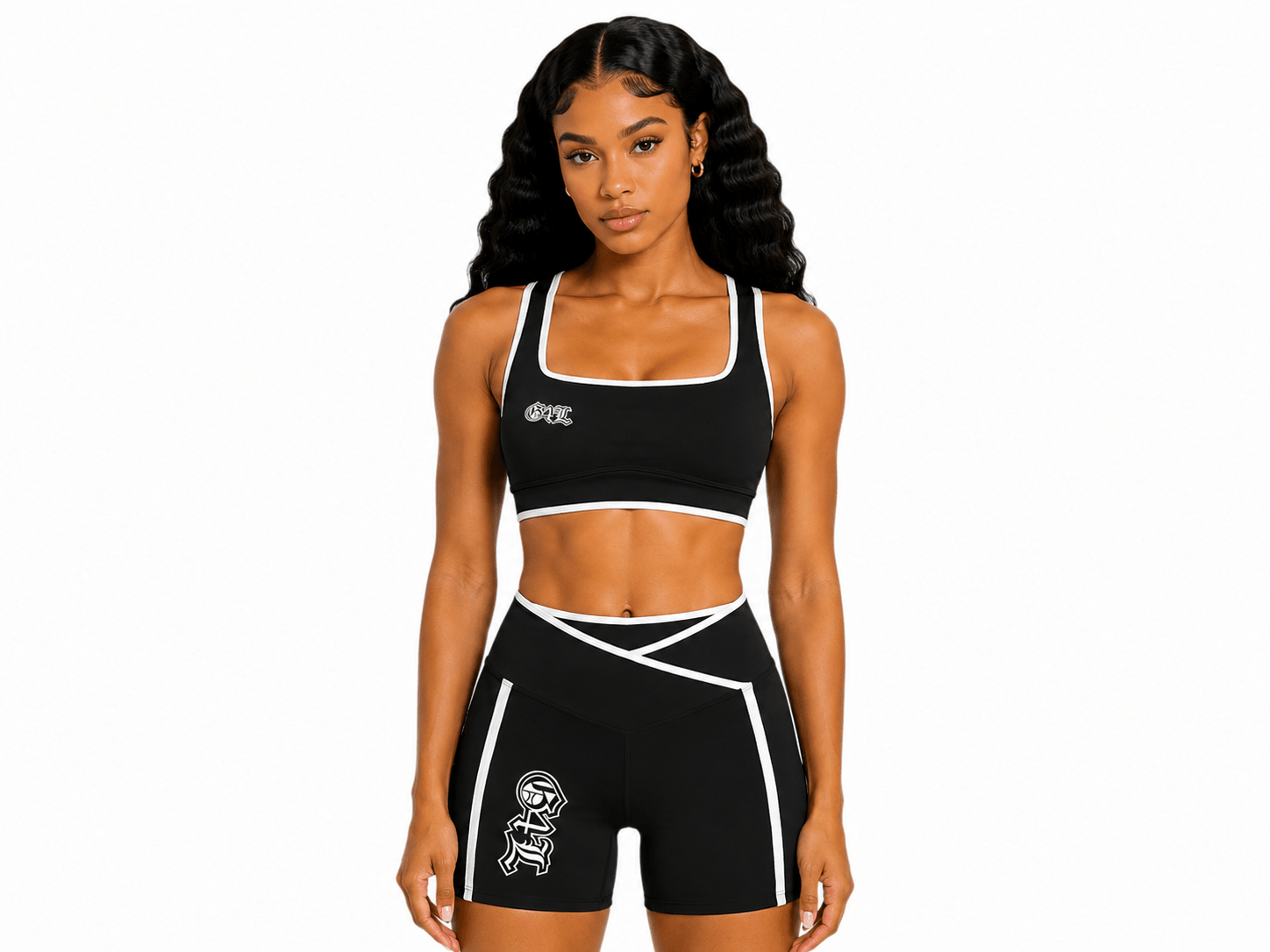 Woman wearing a black sports bra and shorts with a logo on a white background
