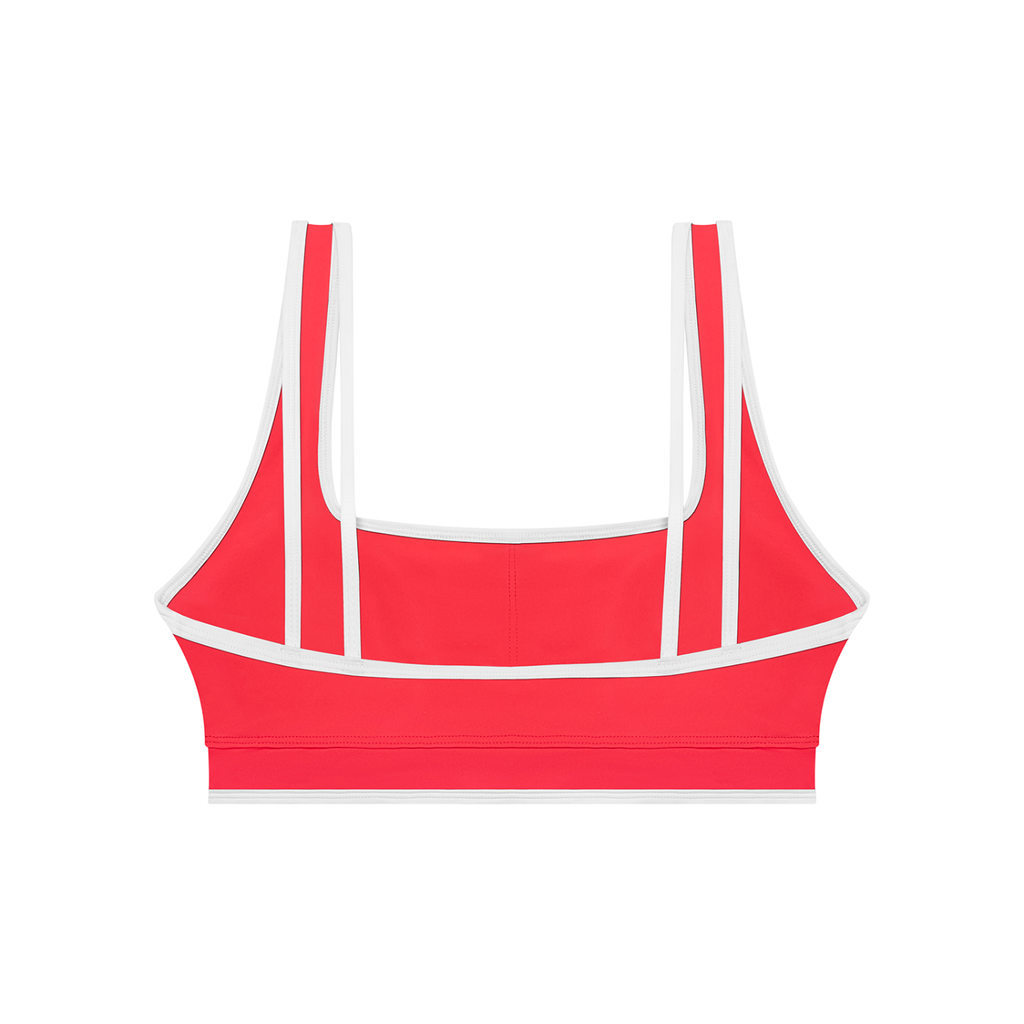 Red sports bra with white straps on a white background