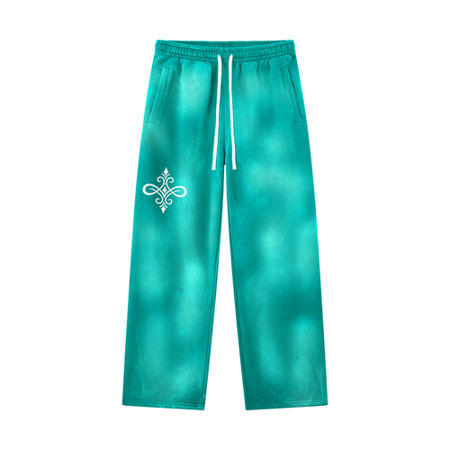 A pair of teal and turquoise tie-dye sweatpants with a white drawstring and a white decorative emblem on the left thigh, shown against a plain white background.
