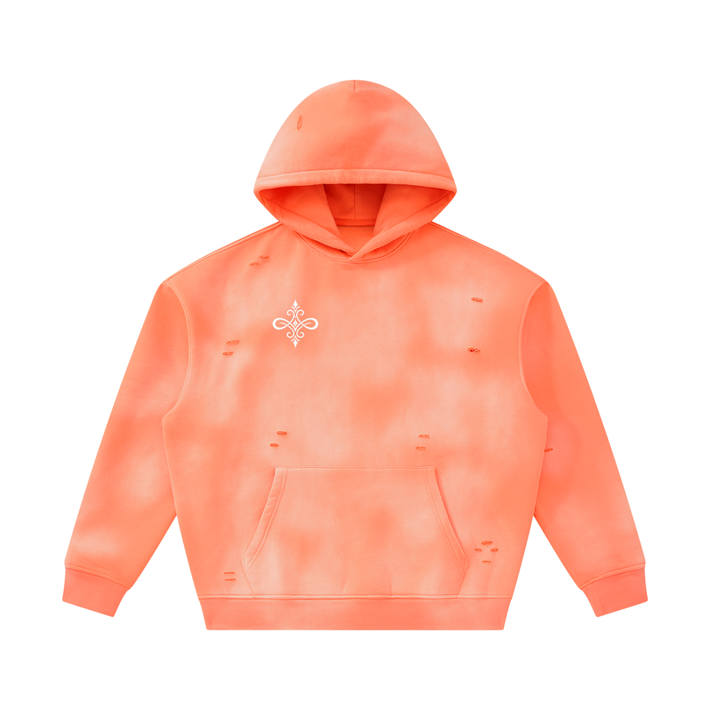 A distressed hoodie in a vibrant orange-coral color with a subtle tie-dye pattern, featuring a small white decorative emblem on the left chest. The hoodie has a front kangaroo pocket and is shown against a plain white background.