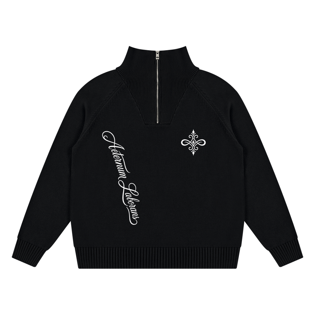 A black long-sleeve knit half-zip sweater with a mock neck, featuring white embroidered script on the right chest and a white fleur-de-lis motif on the left chest, displayed on a solid white background.