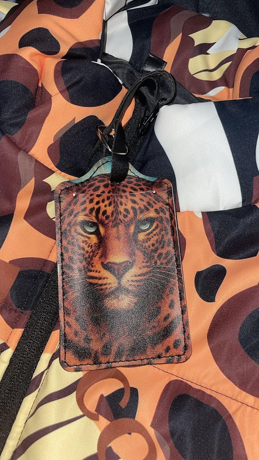 Leopard-themed luggage tag on a multicolored patterned background