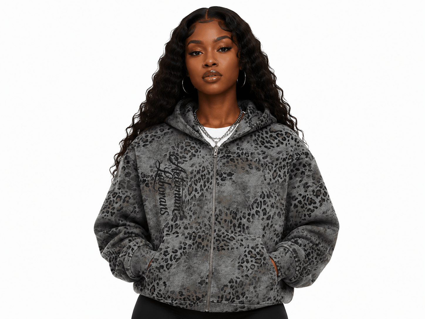 A woman modeling a gray leopard-print zip-up hoodie with black script text on the left chest, photographed against a plain white background.