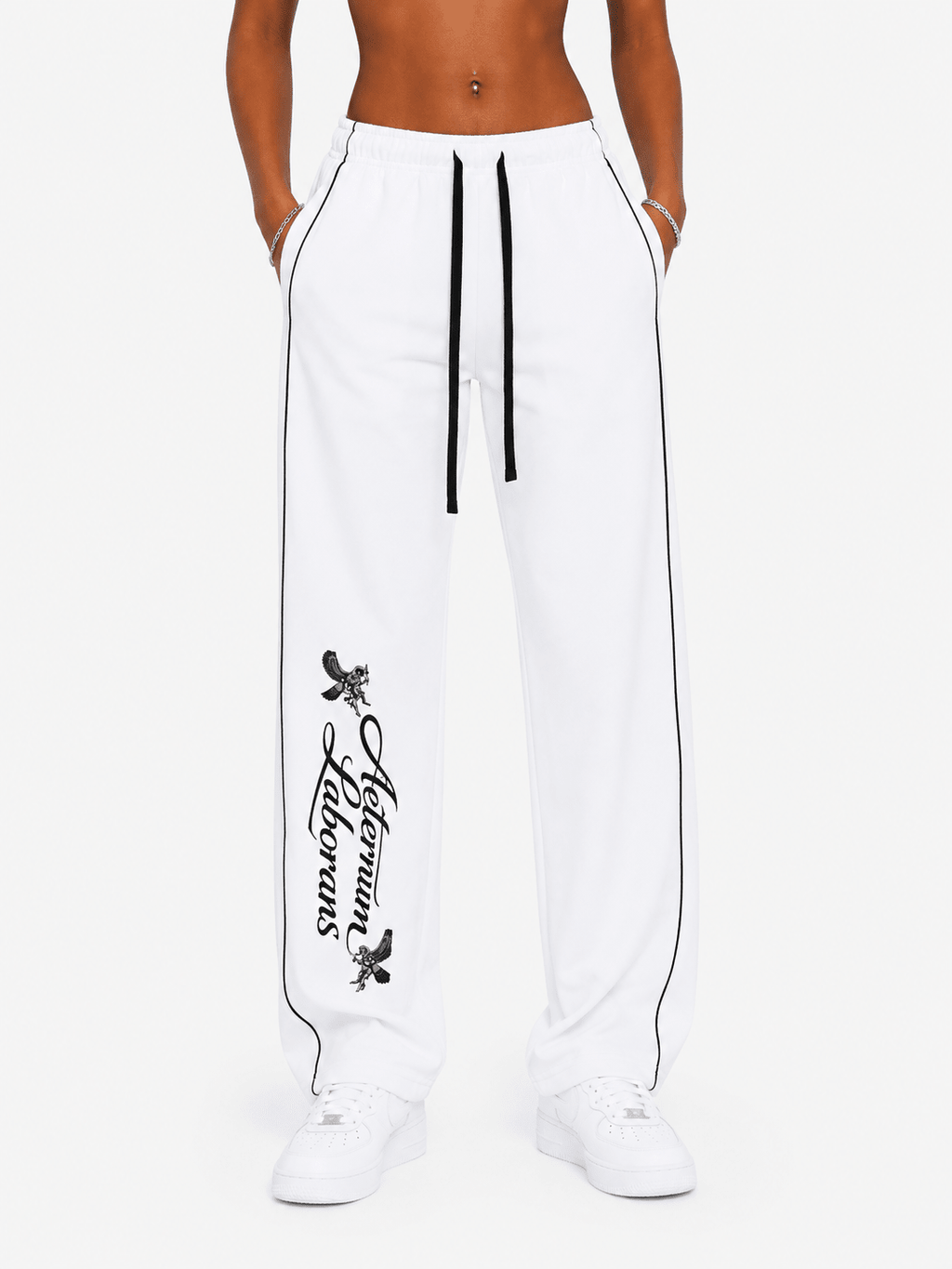 White wide-leg sweatpants with black side piping, a black drawstring, and a black vertical 'Allium Flowers' graphic on the left leg, shown on a model against a light gray background.