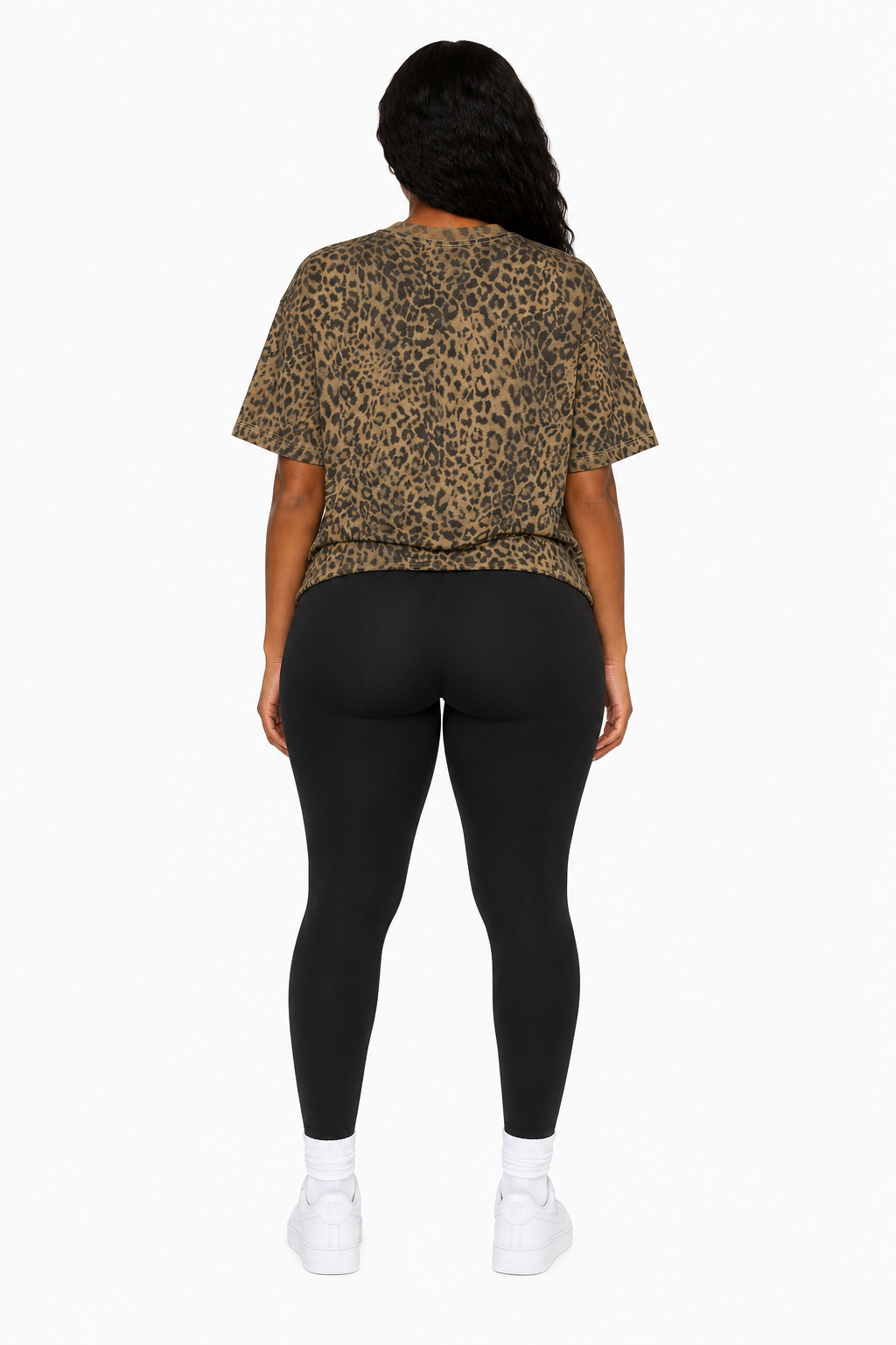Person wearing a leopard print top and black leggings on a white background