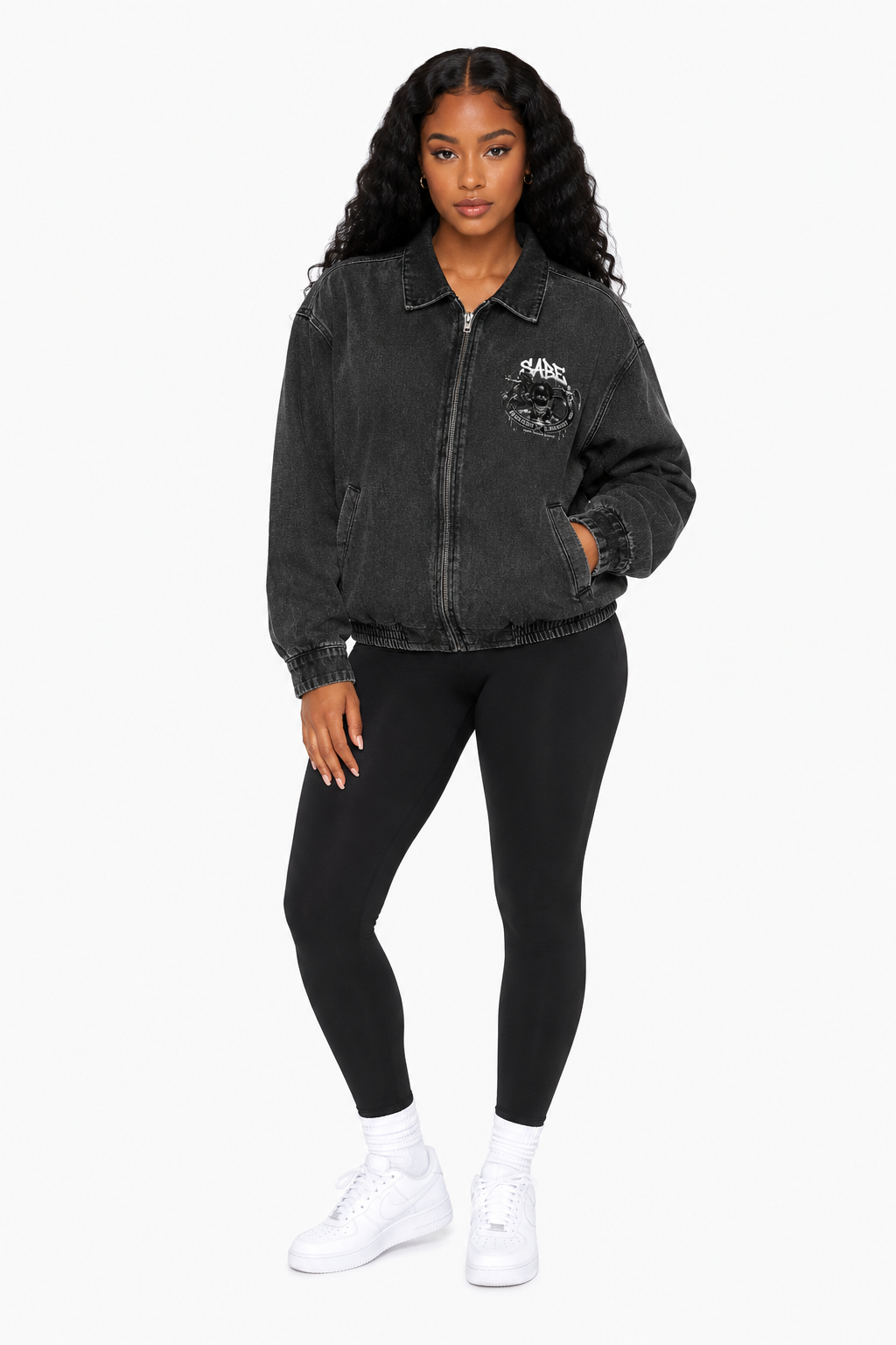 Woman wearing a black denim jacket and leggings on a white background