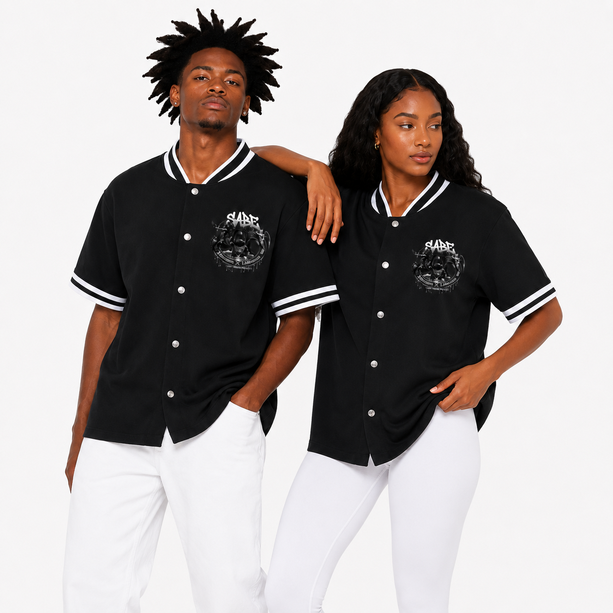 Two people wearing black baseball jerseys with white accents on a plain background