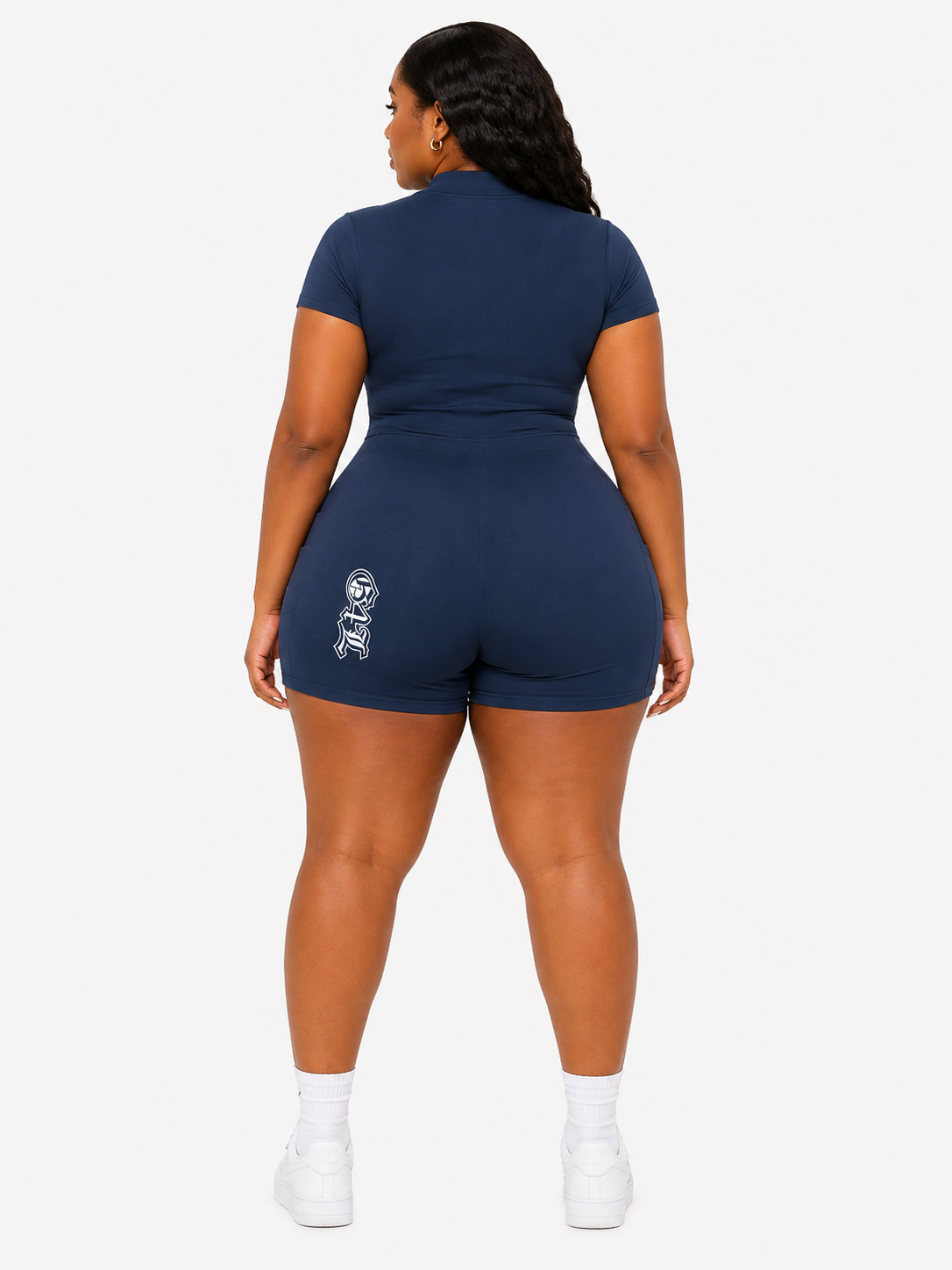 Person wearing a navy blue romper with white text on a white background