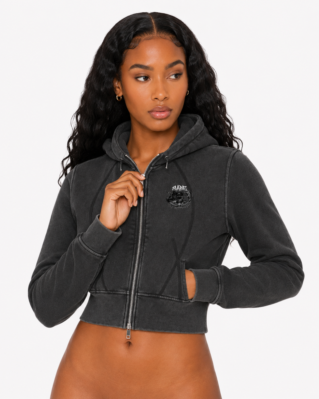 Woman wearing a black cropped hoodie on a white background