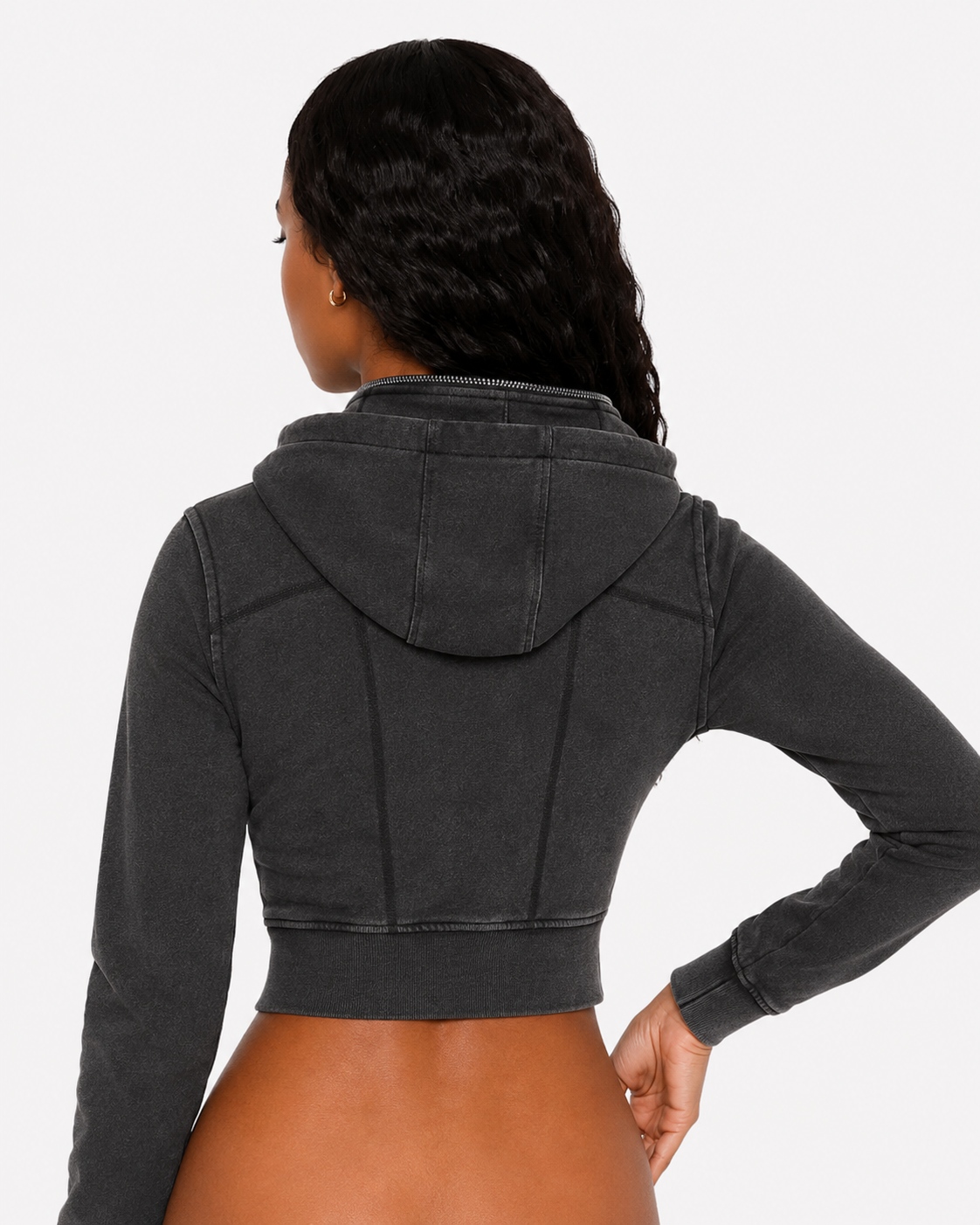 Person wearing a black cropped hoodie on a white background