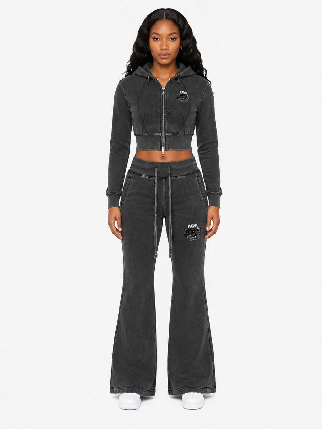 Woman wearing a black tracksuit with a brand logo on a white background