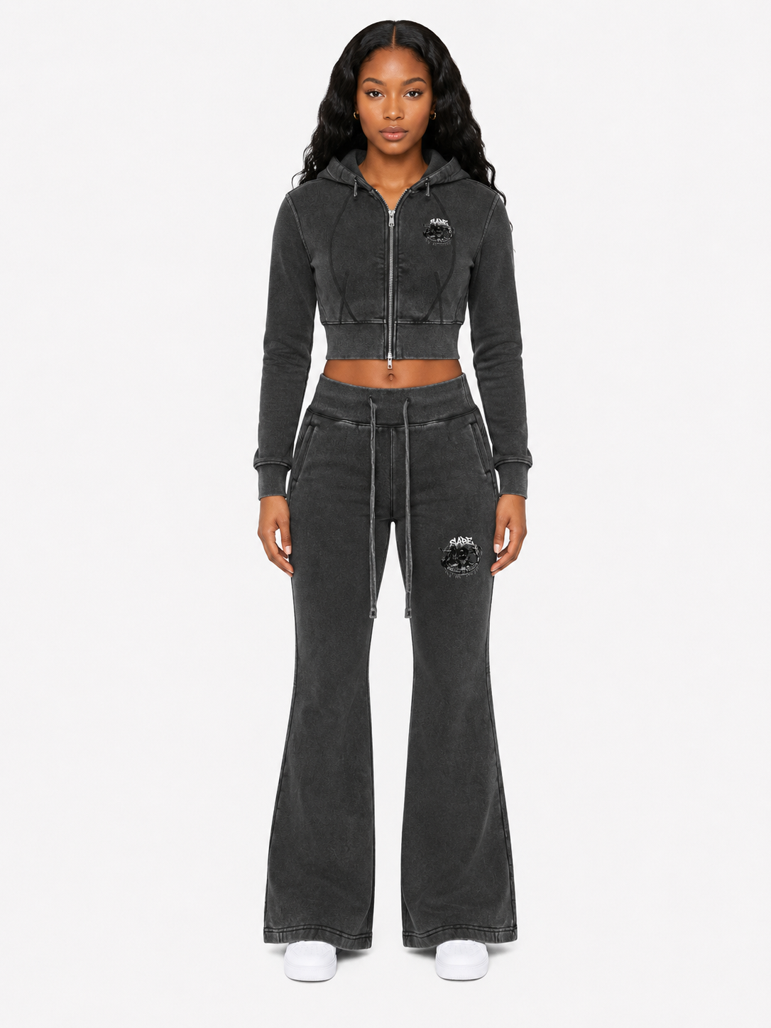 Woman wearing a black tracksuit with a brand logo on a white background