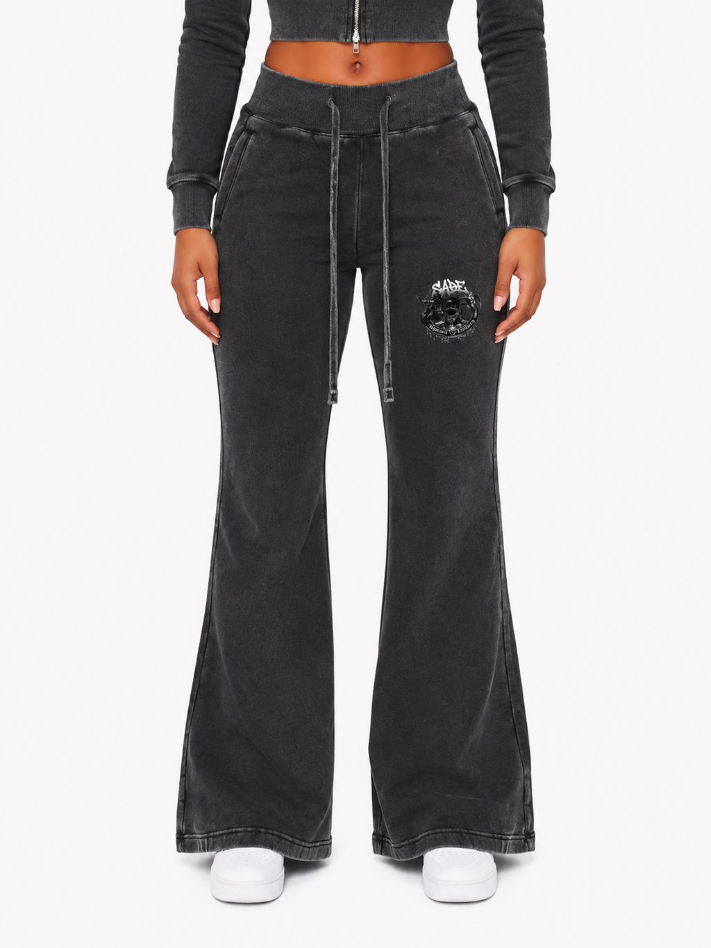 Black flared pants with a brand logo on a white background