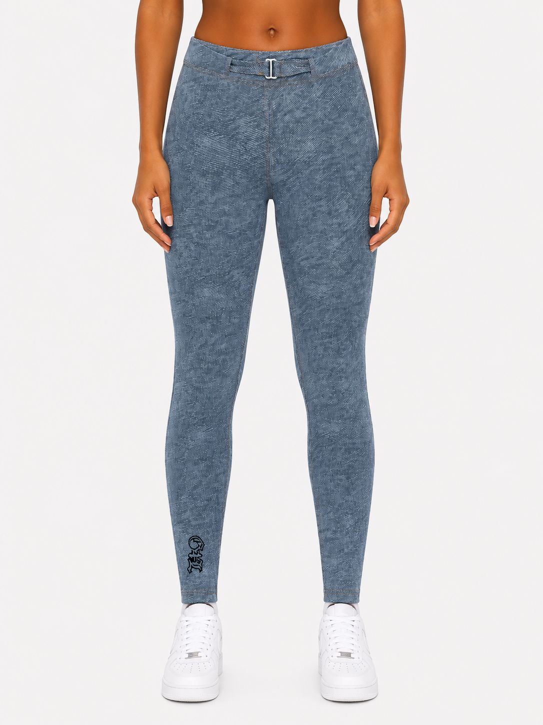 Person wearing blue leggings with a small logo on a white background