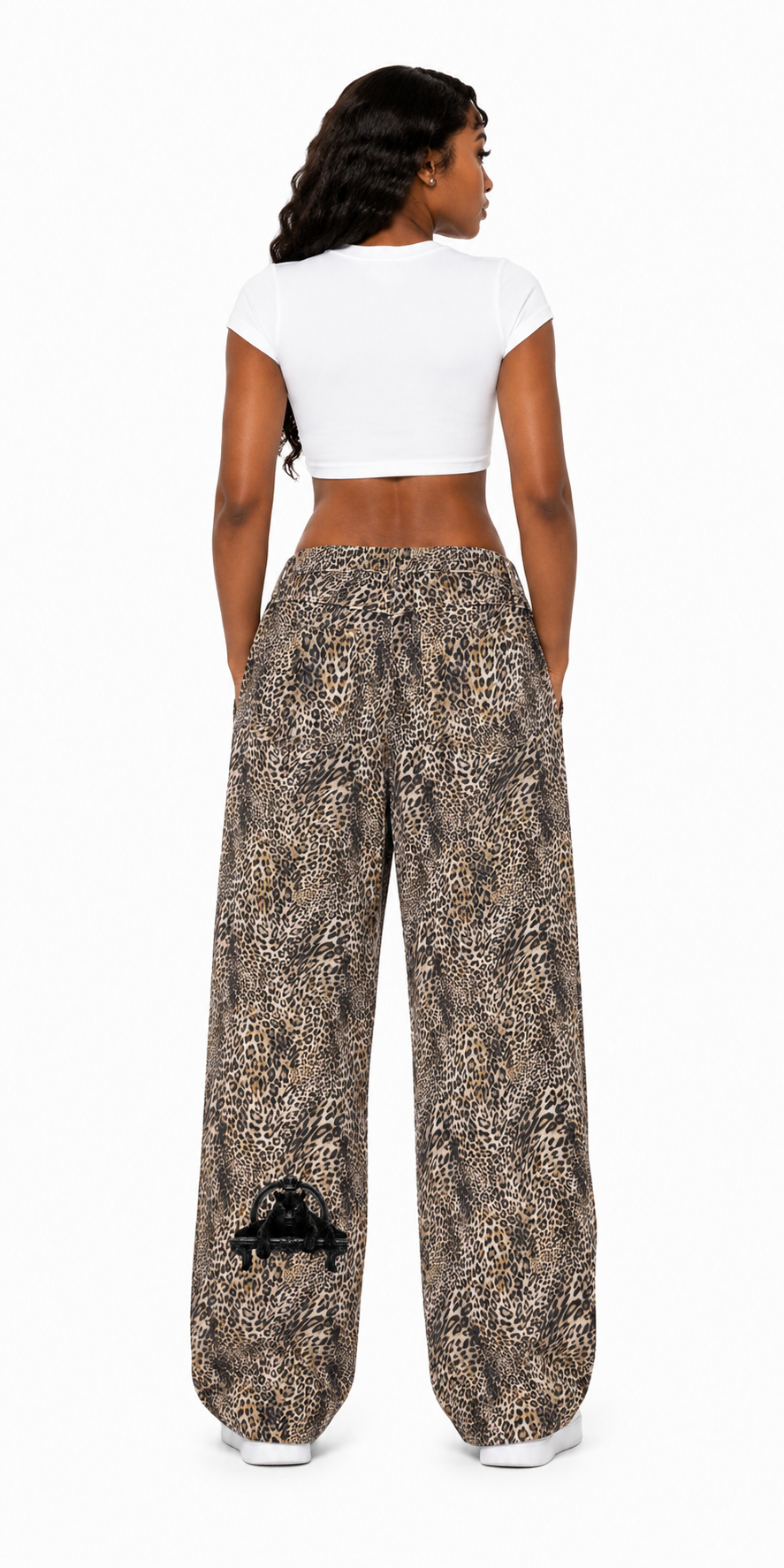 Woman wearing a white crop top and patterned wide-leg pants on a white background