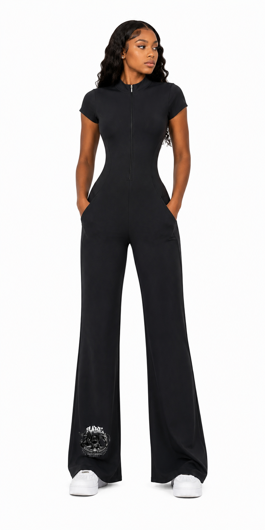 Woman wearing a black jumpsuit with white sneakers on a white background