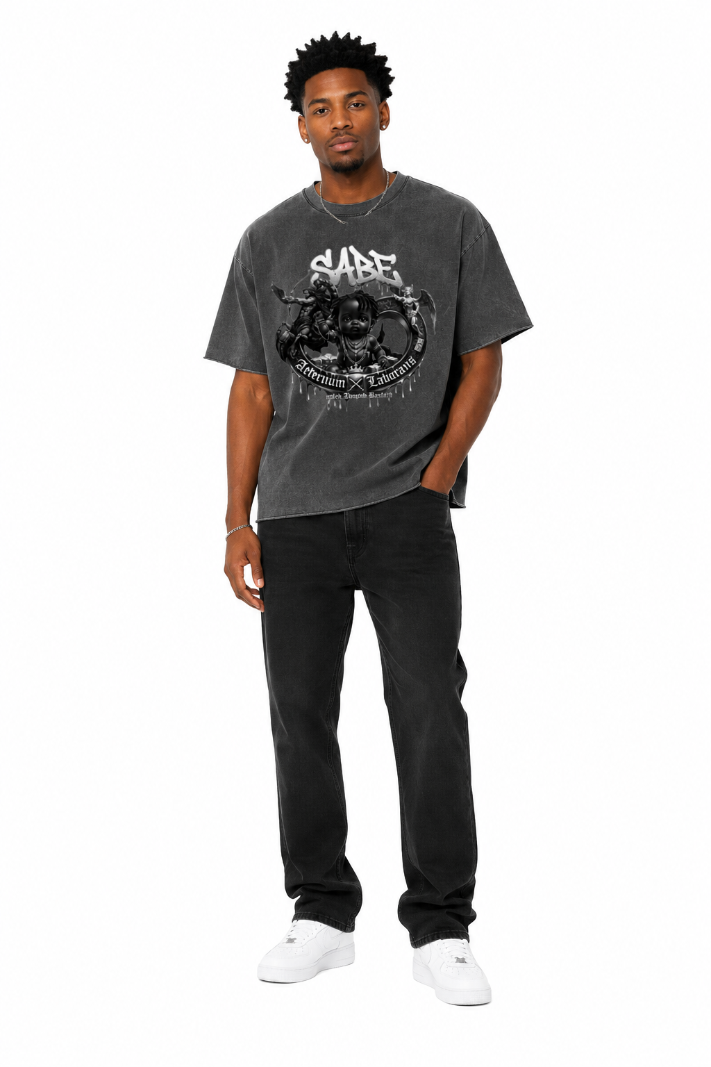 Man wearing a dark gray t-shirt with a graphic design and black pants on a white background