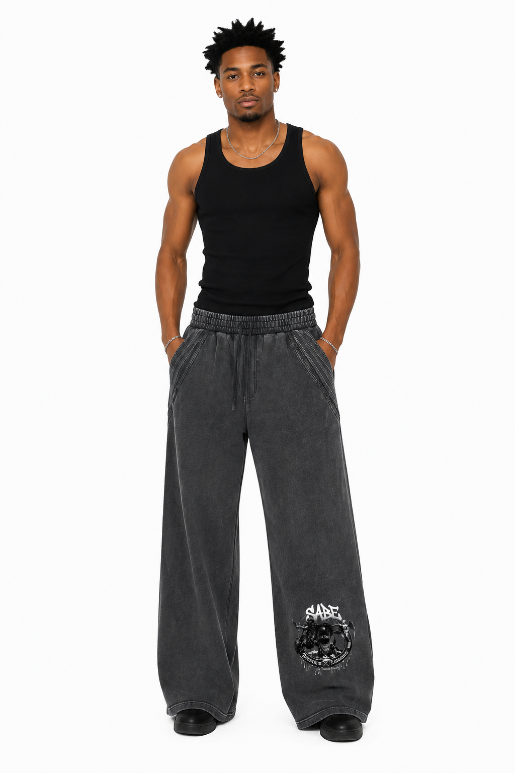 Man wearing a black tank top and gray sweatpants with a logo on a white background