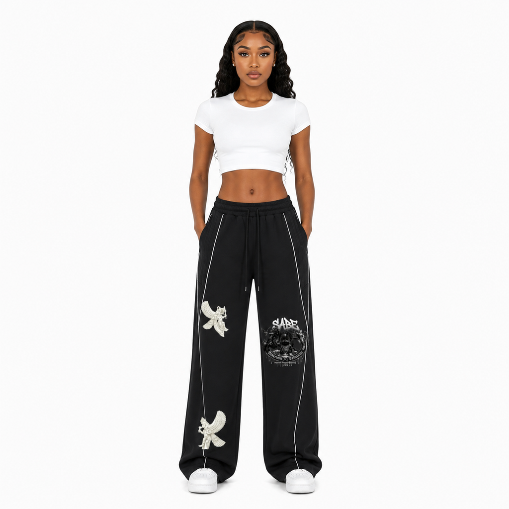 Woman wearing a white crop top and black pants with white designs on a white background