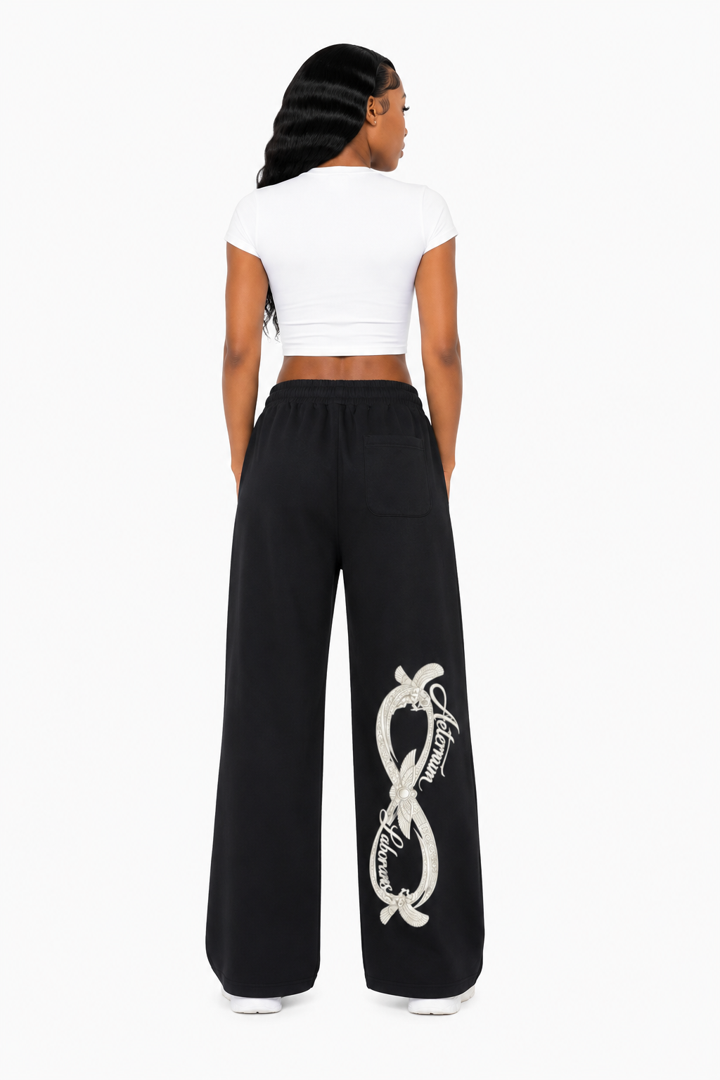 Person wearing black pants with a white snake design on a white background