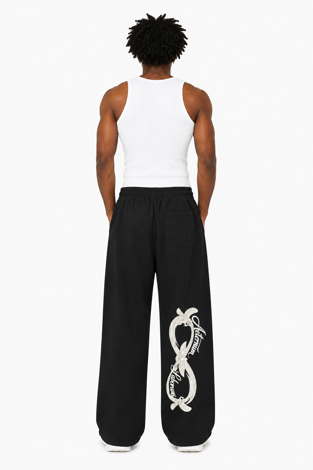 Person wearing a white tank top and black pants with a snake design on a white background