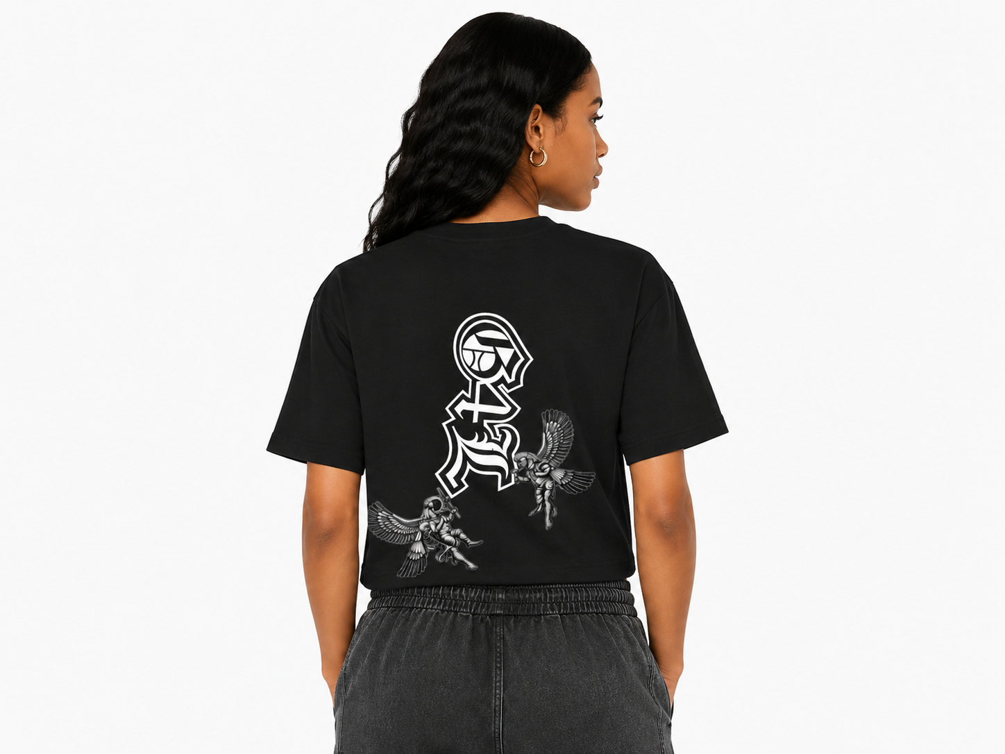 Person wearing a black t-shirt with white graphics on the back, standing against a white background