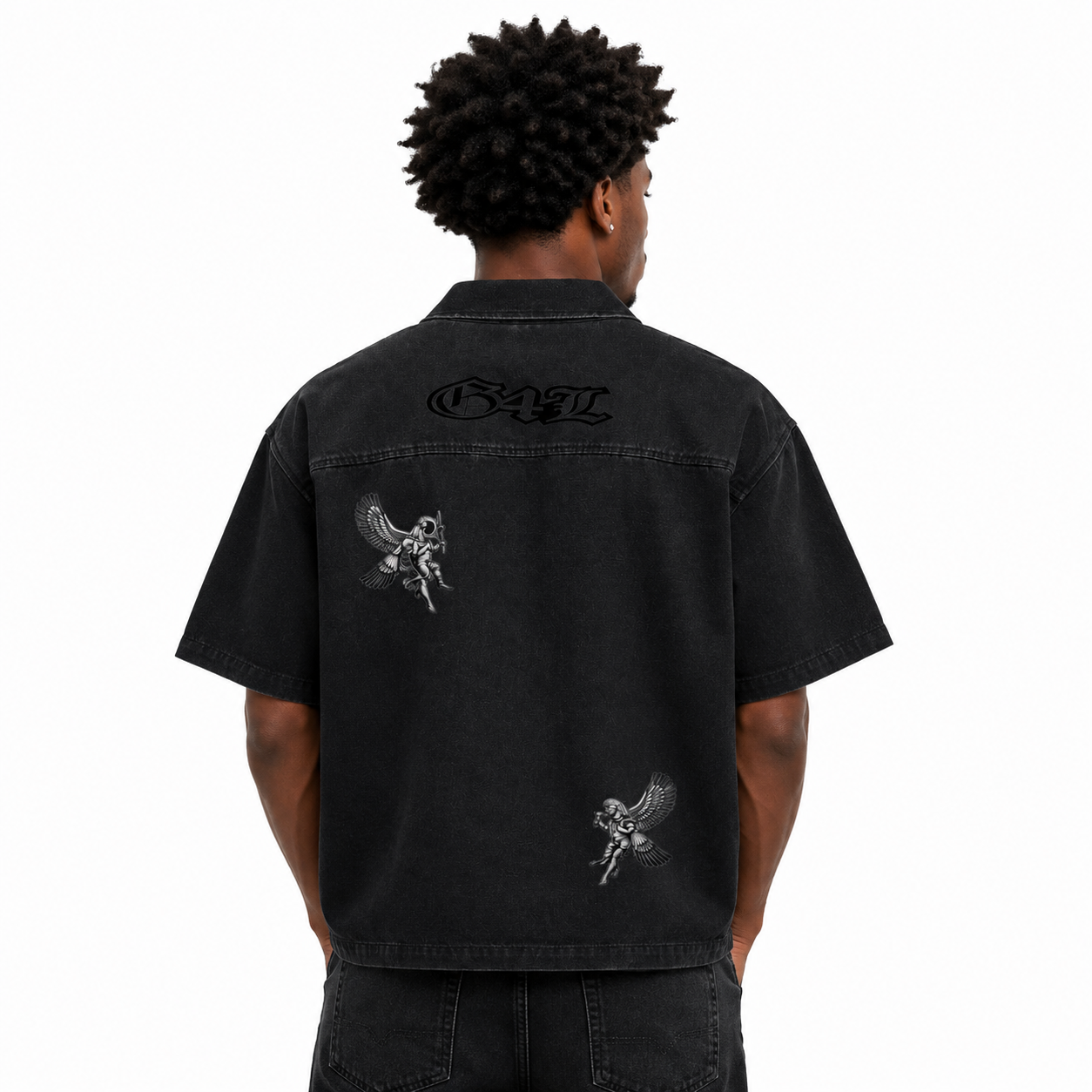 Person wearing a black shirt with designs on the back, on a white background