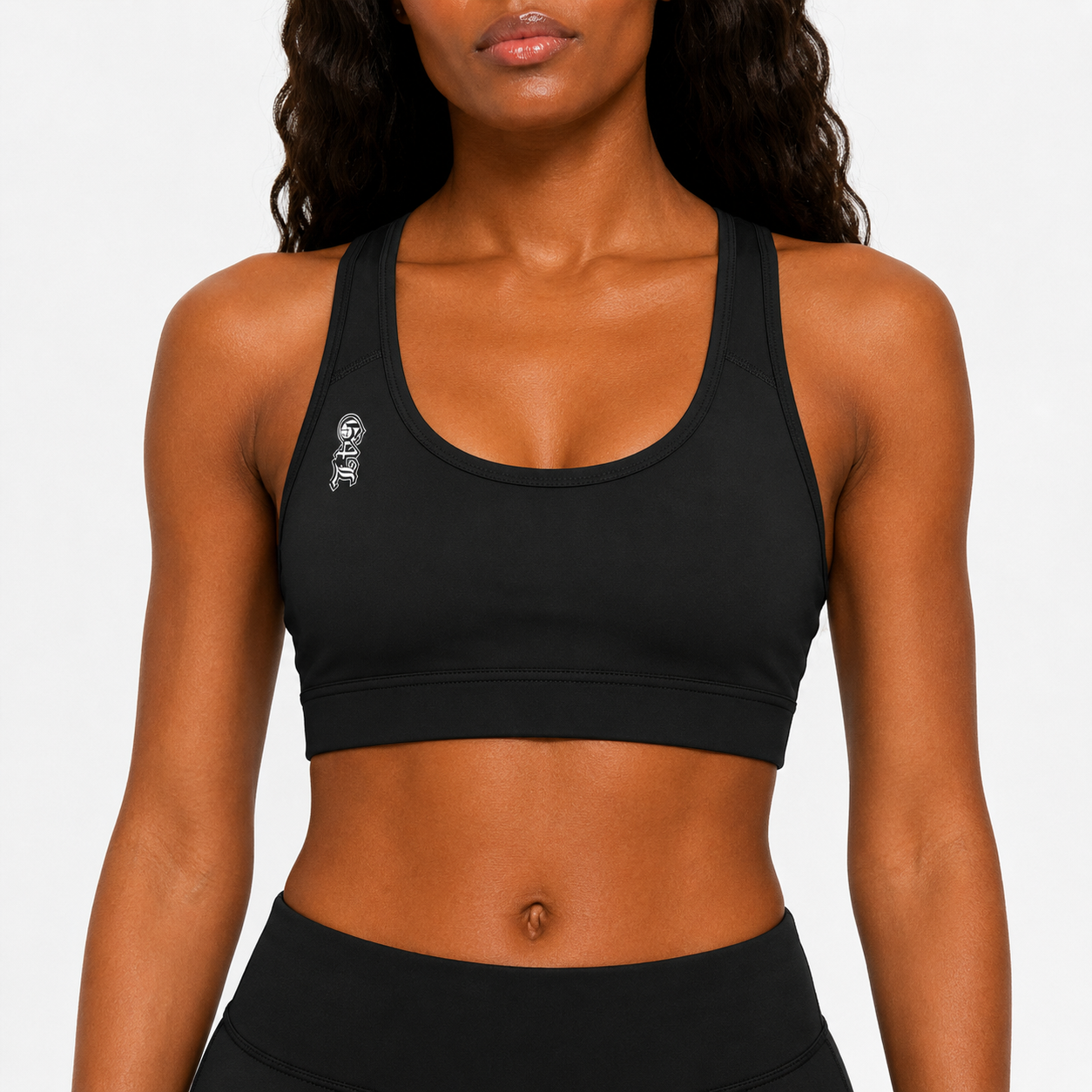 Woman wearing a black sports bra with a logo on a plain background