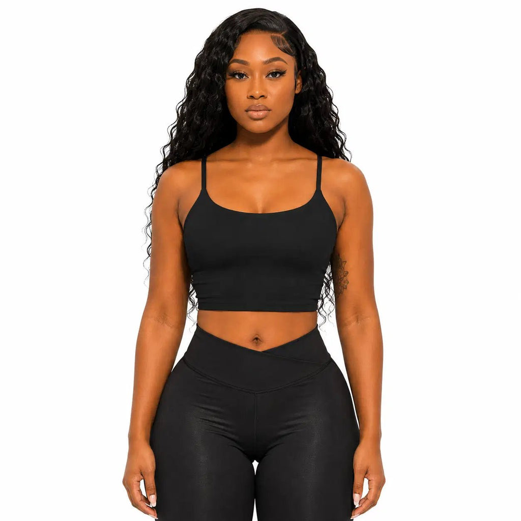 Woman wearing a black sports bra and leggings on a white background