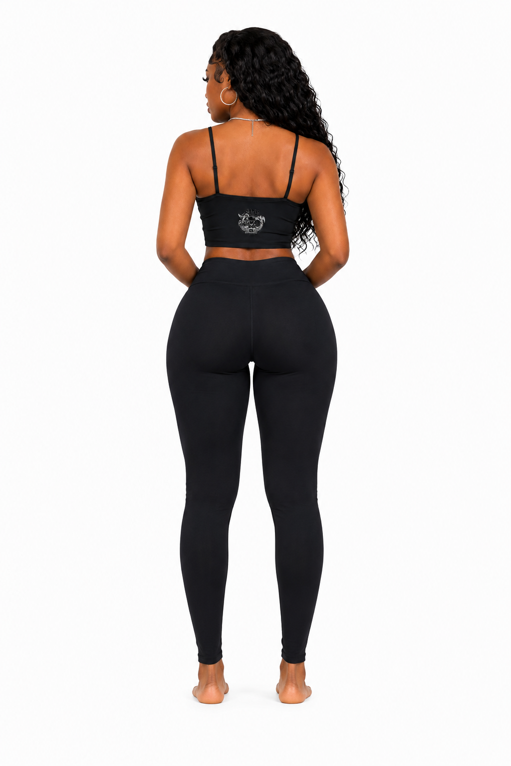 Person wearing a black sports bra and leggings set on a white background