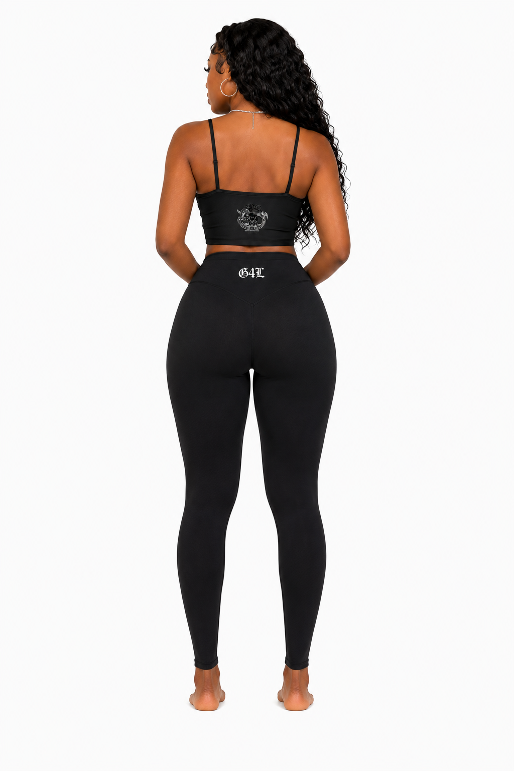 Person wearing a black sports bra and leggings set on a white background