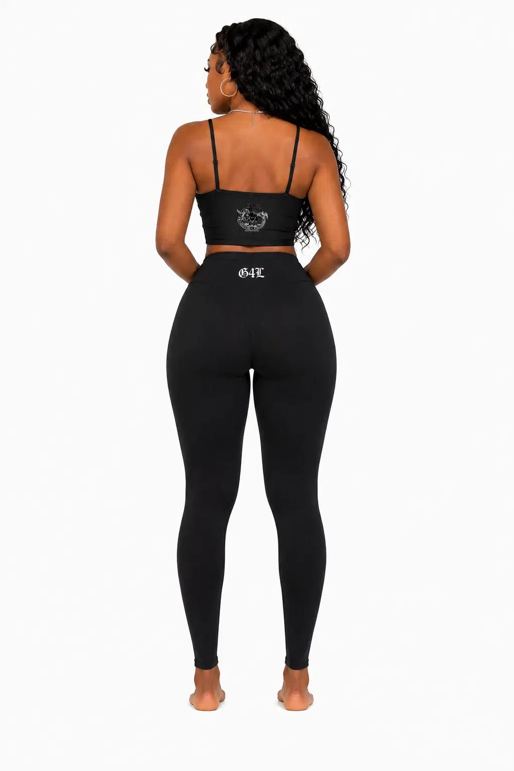 Person wearing a black sports bra and leggings set on a white background