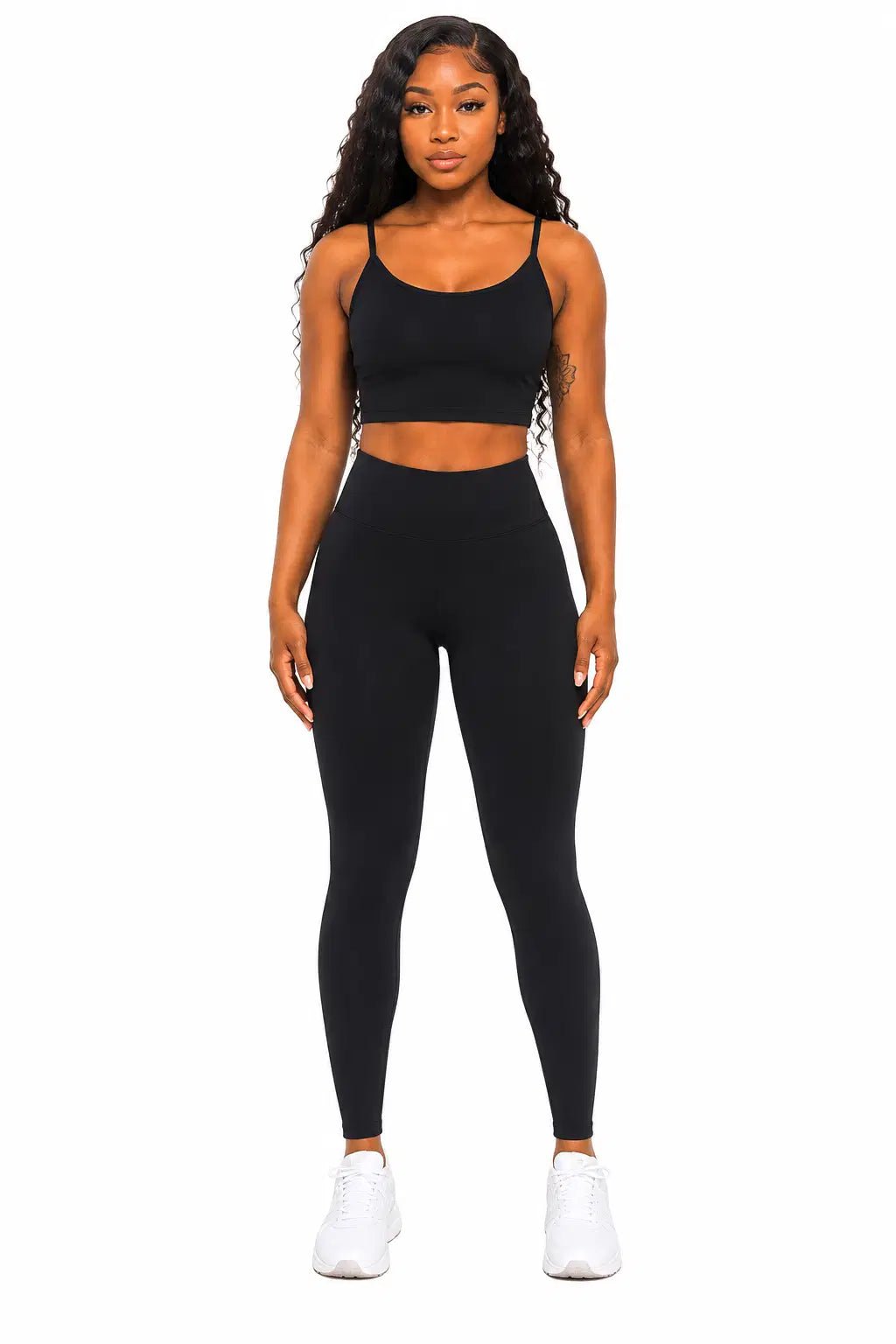 Woman wearing a black athletic outfit on a white background
