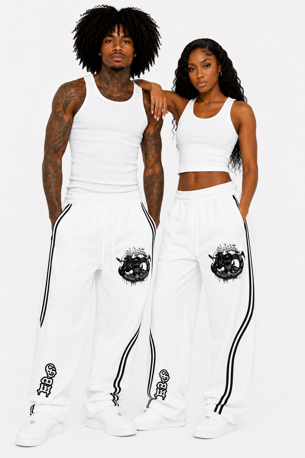 Two people wearing matching white outfits with black designs on a plain background