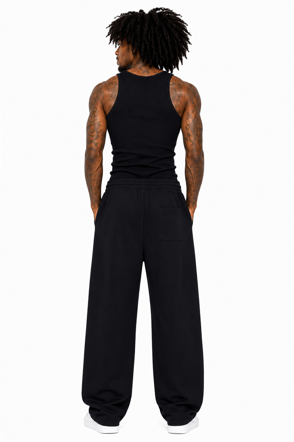Person wearing a black tank top and black pants on a white background