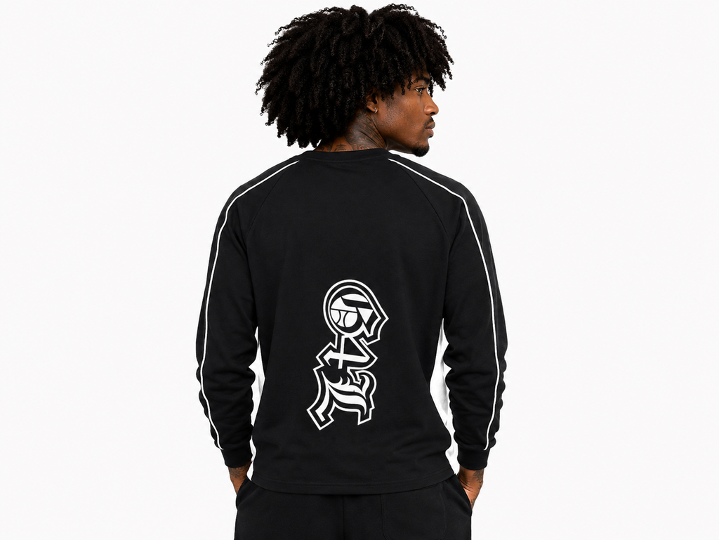Person wearing a black tracksuit with a white logo on the back against a white background