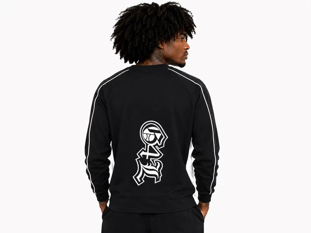 Person wearing a black tracksuit with a white logo on the back against a white background