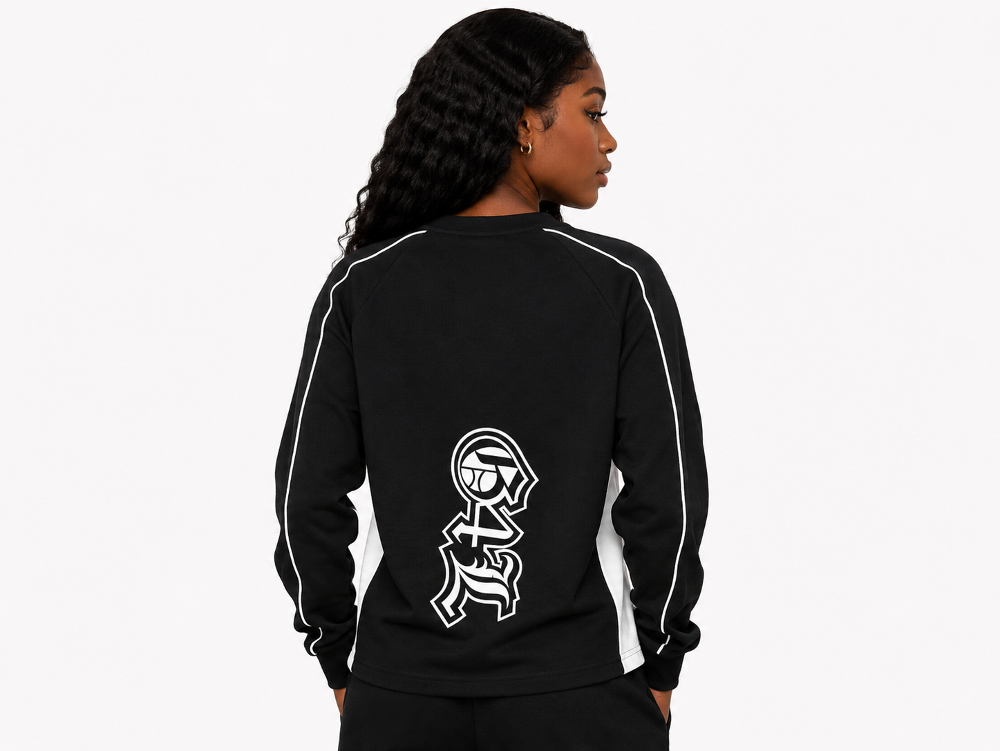 Person wearing a black tracksuit with a white graphic on the back against a white background