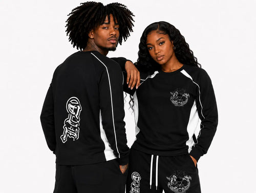 Two people wearing black tracksuits with white designs on a plain background