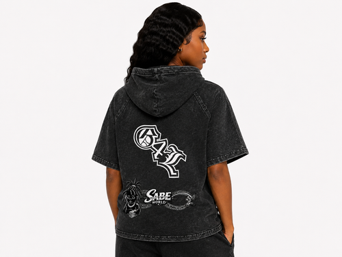 Person wearing a black hoodie with logos on the back against a white background