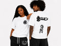 Two people wearing white t-shirts with black graphics on a plain background