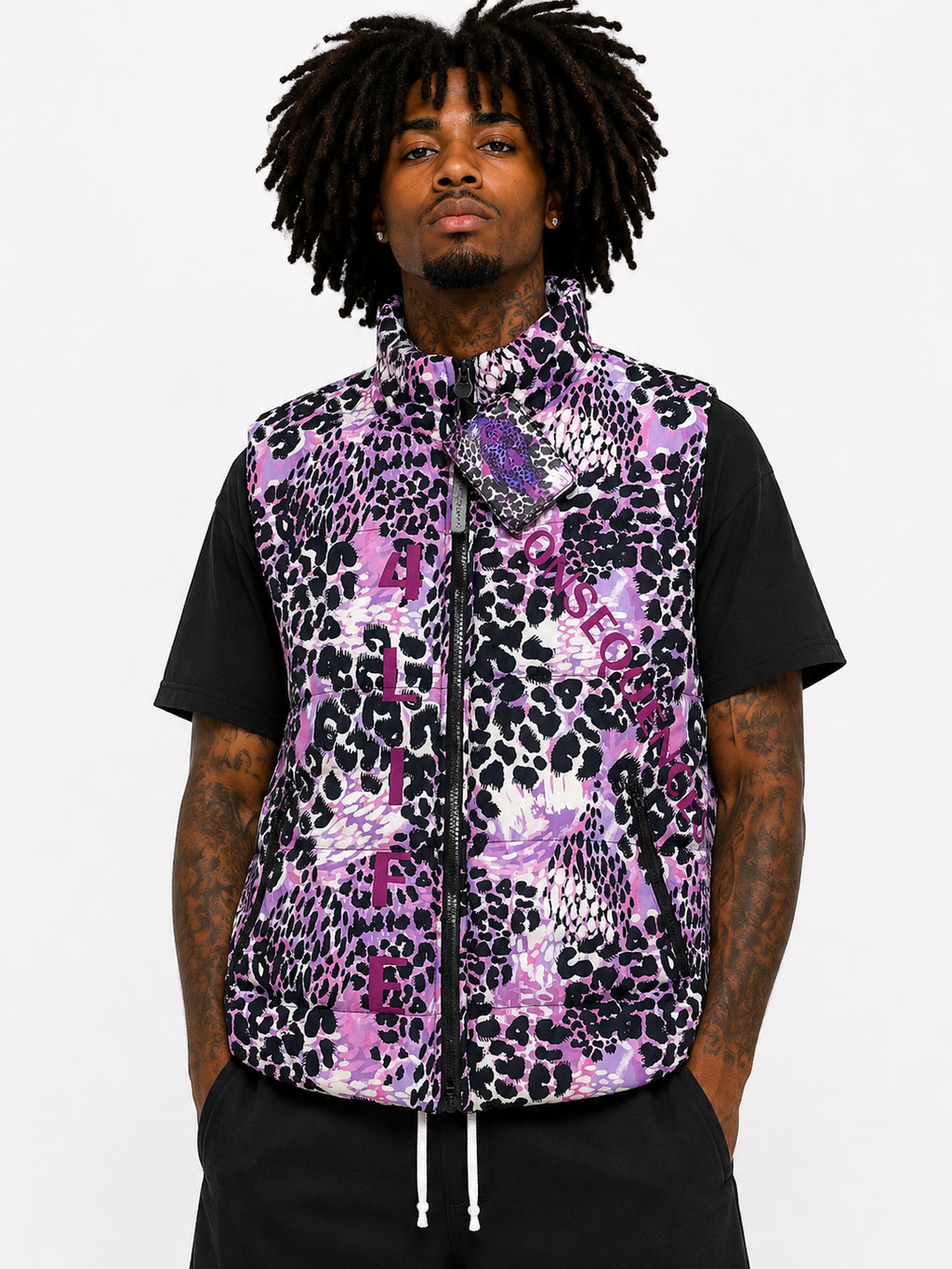 Person wearing a purple and black patterned vest over a black shirt on a white background