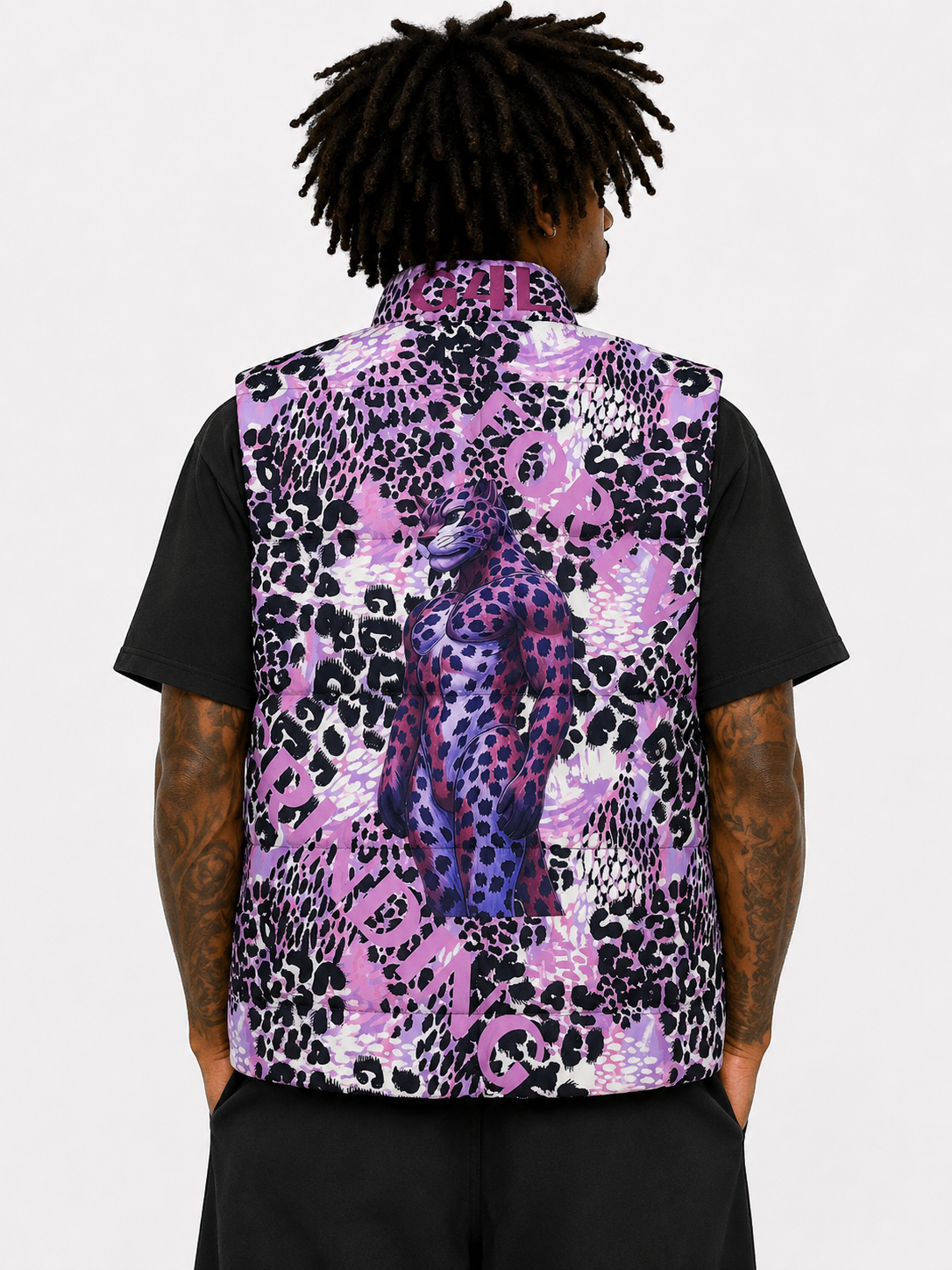 Person wearing a black shirt with a purple and black leopard print vest on a white background