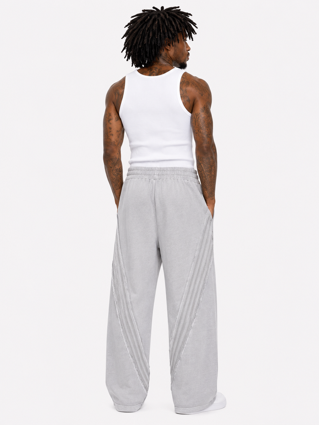 Person wearing a white tank top and gray sweatpants on a white background