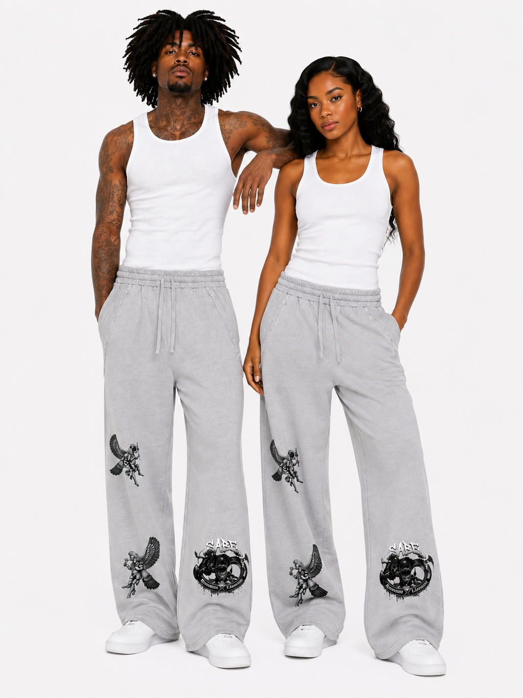 Two people wearing matching gray sweatpants with black designs on a white background