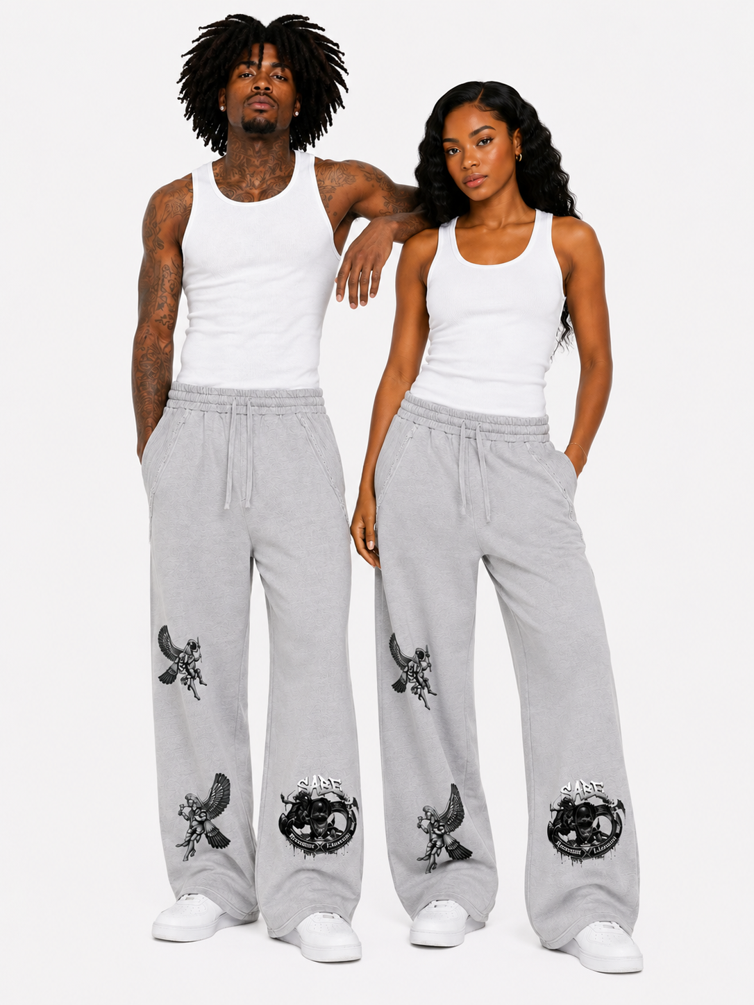 Two people wearing matching gray sweatpants with black designs on a white background