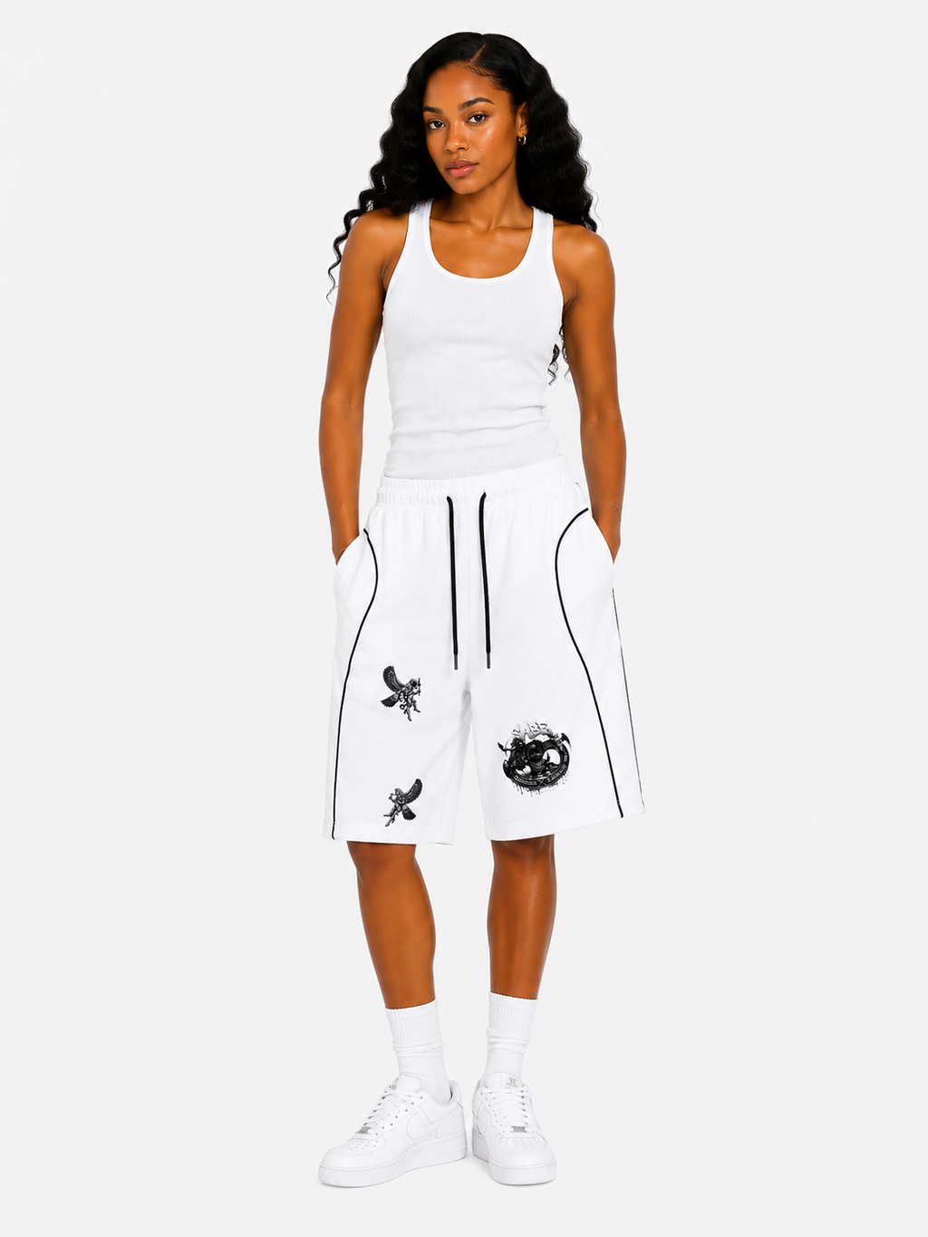 Woman wearing a white tank top and black and white shorts with designs on a white background