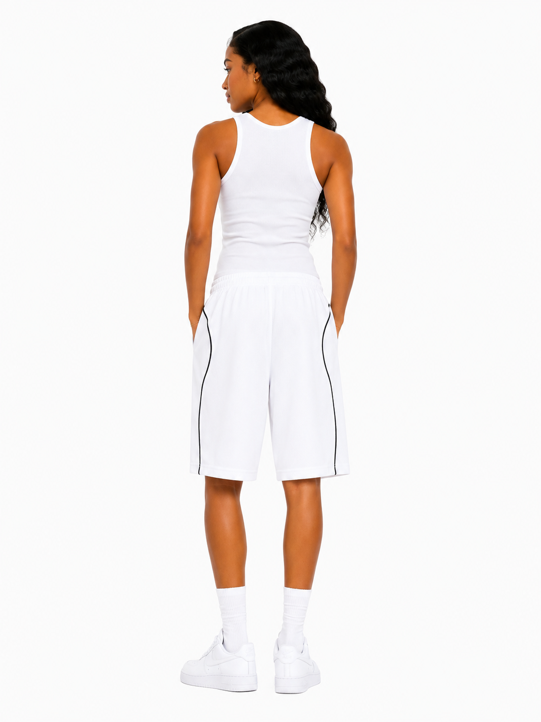 Woman wearing a white sleeveless dress with black trim on a white background
