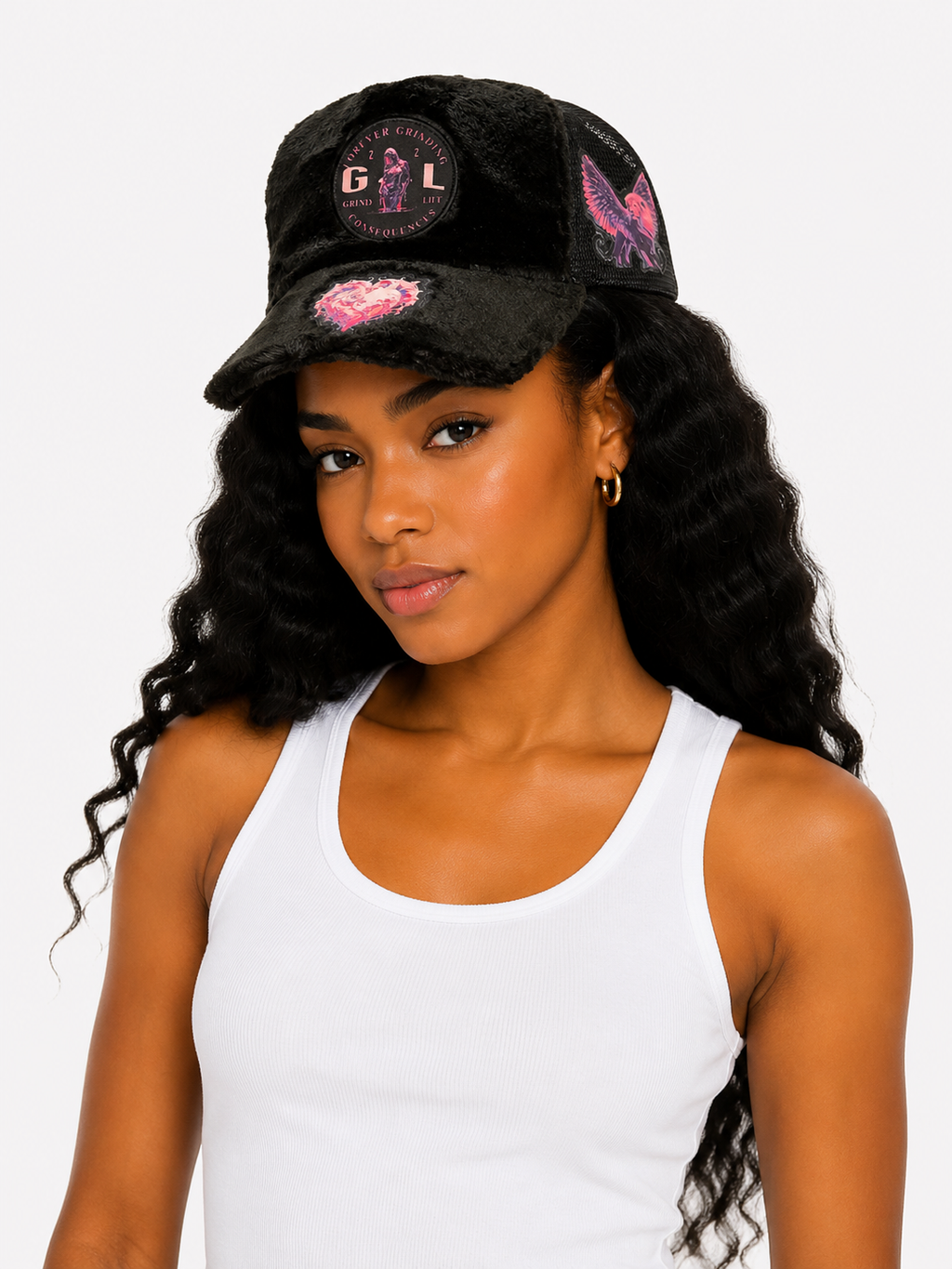 Woman wearing a black cap with pink designs on a white background