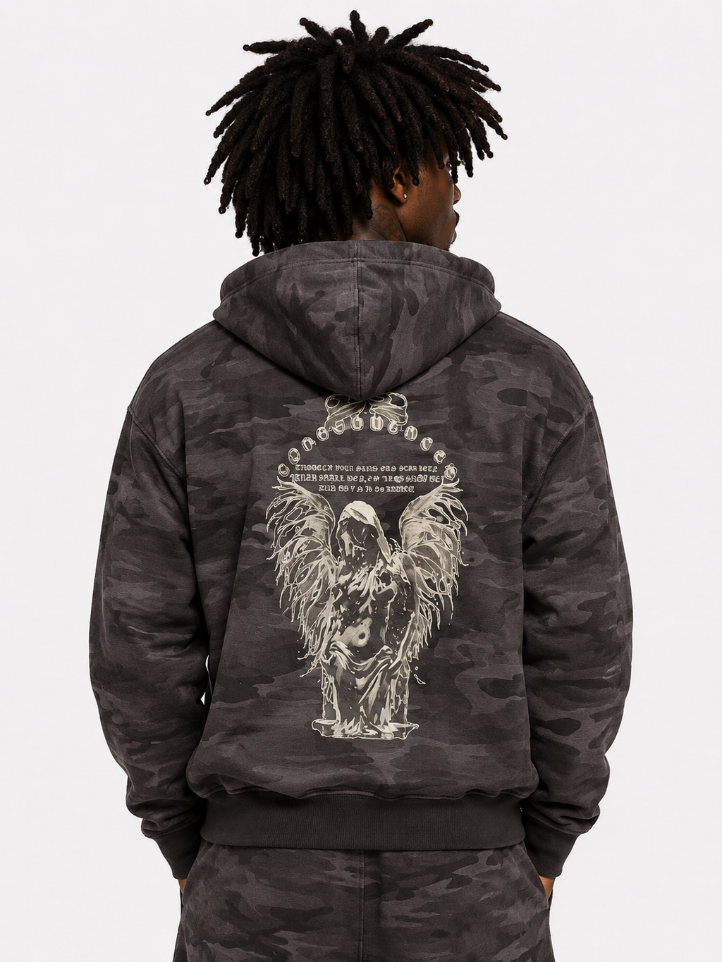 Person wearing a dark camouflage hoodie with an angel design on the back against a white background